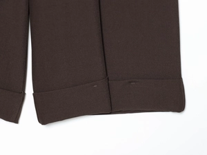 Dettaglio di pantaloncini in twill marrone con orlo arrotolato e trama del tessuto