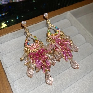 Detail von Quastenohrringen mit bunten Zirkonias und rosa Perlen auf Schmucktablett