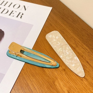 French vintage emerald green and pearlescent marble hair clips set on wooden table