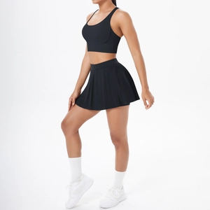 Vue latérale d'un ensemble sport noir avec brassière croisée et jupe plissée pour fitness