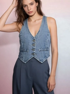 Detailed view of light blue denim vest with metal buttons and decorative pockets