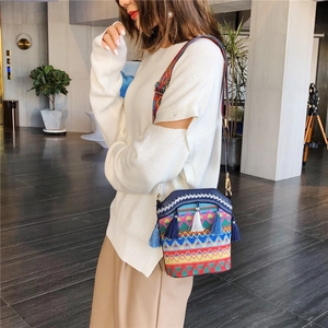Ethnic style bucket bag with colorful woven texture and tassel accents on wide strap
