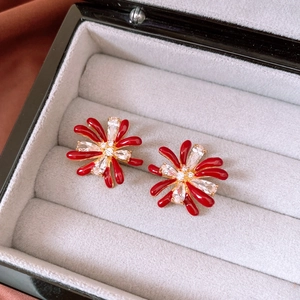 Detailed macro view of 18k gold plated flower stud earrings with red petals and zircons