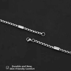Macro view of silver stainless steel box chain with lobster clasp and cylinder accents