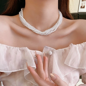 Detail of bohemian multilayer pearl necklace showing elegant vintage strands on a model neck