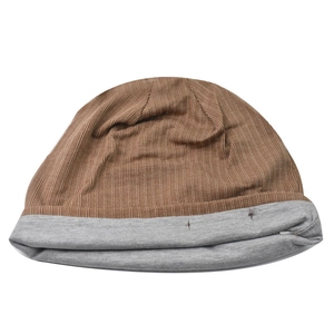 Detail of a brown corduroy and grey knit patchwork beanie with a ribbed texture top