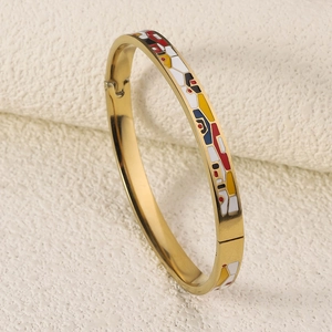 Detail of 18K gold plated titanium bangle featuring colorful enamel geometric patterns