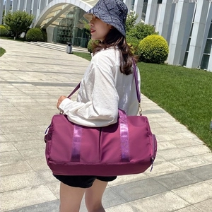 Purple large capacity yoga gym bag with shoe compartment shown being carried by model