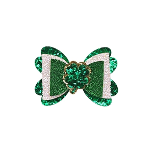 Detail of glitter St. Patrick's Day hair bow with green shamrock and gold accents