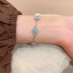 Détail d'un bracelet en argent avec trois pierres turquoise rondes et zircons brillants