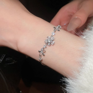 Détail macro d'un bracelet fleuri en argent orné de zircons étincelants sur un poignet