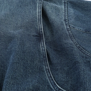 Detailopname van dubbel stiksel en textuur op vintage blauwe denim jasje stof