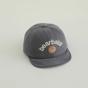 Détail d'une casquette en coton pour bébé avec broderie ours et visière souple grise