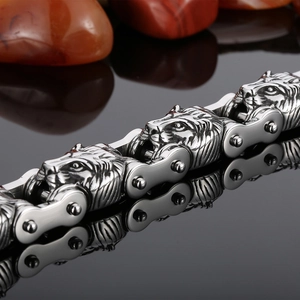 Close-up of silver lion head links on stainless steel biker chain bracelet with reflections