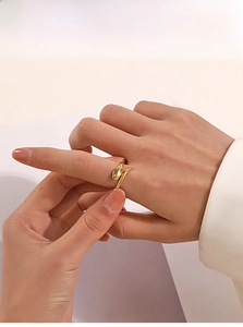 Polished 18K gold plated snake-shaped open ring shown on finger in minimalist setting