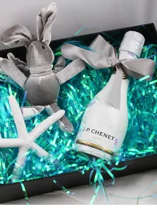 Gift set detail with sparkling iridescent shredded paper filling and plush bunny toy