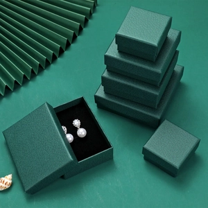 Deep green lychee texture jewelry box with black velvet lining and pearl earrings