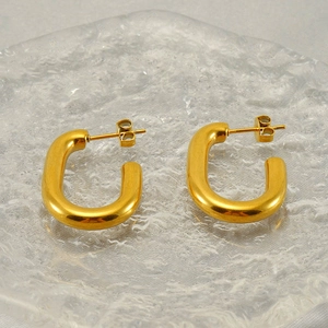 Minimalist gold U-shaped hoop earrings with polished finish on textured glass base