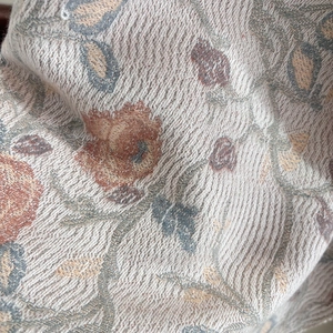 Close-up of ethnic floral jacquard weaving texture with beige and brown thread details