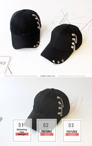 Close-up of black cotton baseball cap featuring silver metal chains and punk style rings