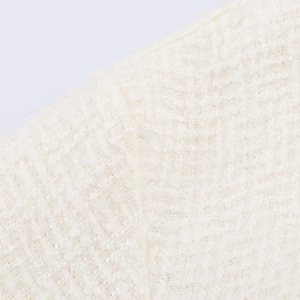 Nahaufnahme der cremefarbenen Bouclé-Tweed-Struktur mit detailliertem Fasermuster