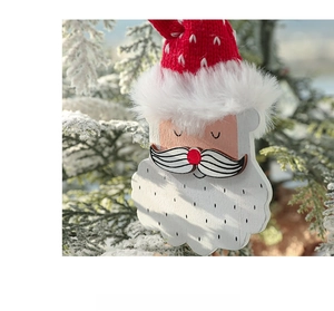 Close-up of a wooden Santa ornament with a red knitted hat and white plush trim