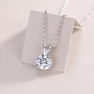 Close-up of a silver moissanite pendant necklace with a round sparkling solitaire stone