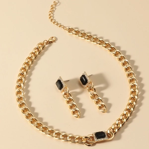 Golden chunky chain necklace and black gemstone earring set in a punk choker style