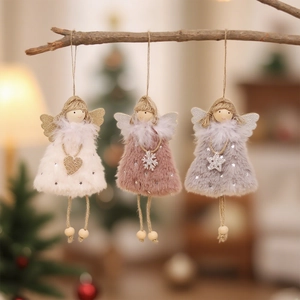 Three plush Christmas angel girl ornaments in white pink and grey hanging on branches
