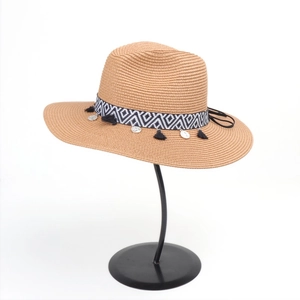 Detail of woven straw hat with black white geometric band and silver tassels