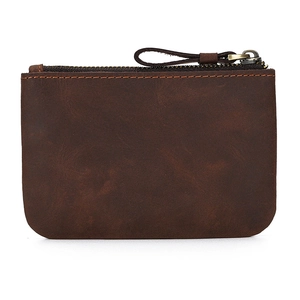 Macro detail of dark brown crazy horse leather texture on a compact zippered coin pouch