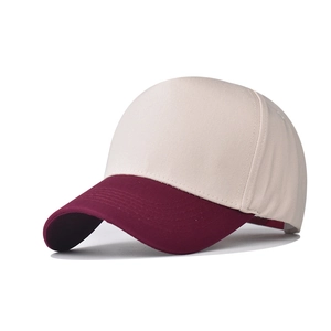 Close-up of the cotton canvas texture and stitching on the wine red baseball cap brim