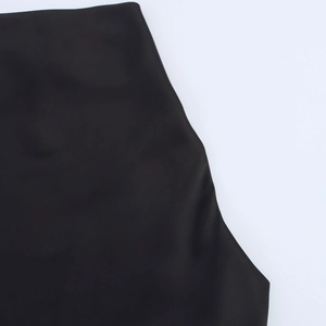 Close-up detail of smooth black satin fabric on a halter neck mini dress for women