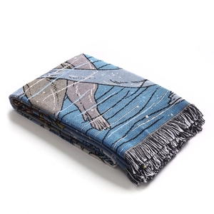 Close-up of bohemian woven picnic blanket with blue patterns and fringe edges