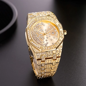 Detailed view of the gold-tone luxury watch with iced-out crystals and octagonal bezel