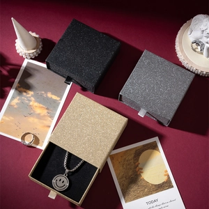 Close-up of glitter finish drawer jewelry boxes in gold, silver, and black colors