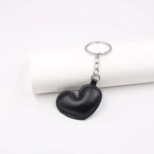 Minimalist black PU leather heart-shaped keychain with silver metal ring on white background