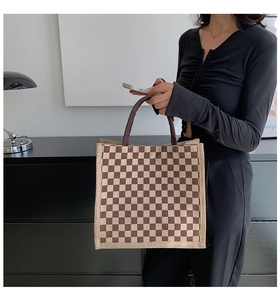 Detail of checkered linen tote bag with reinforced thick handles and burlap texture