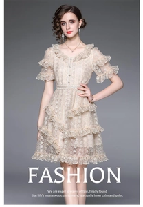 Detailed view of the luxury embroidery lace and ruffled layers on the beige dress
