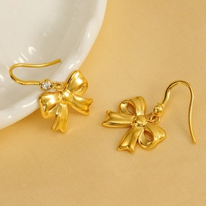Elegant 18K gold plated bow earrings with crystal accent on silk background