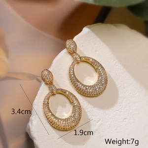 Macro shot of gold plated oval earrings with zircon inlay showing size 3.4cm by 1.9cm