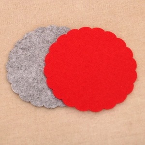 Detail of red and grey felt coasters with scalloped edges for Christmas table decor