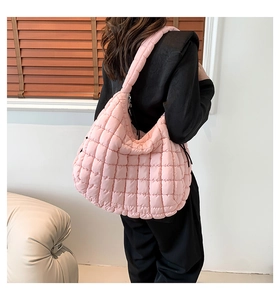Detailed back view of model wearing a pink quilted puff tote bag with textured ruffles
