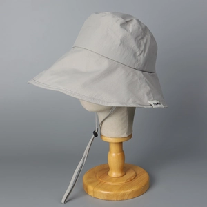 Détail du chapeau de soleil gris à large bord avec cordon de serrage coupe-vent réglable