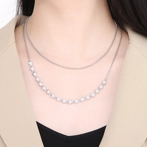 Detail of silver double-layered heart necklace with faux pearls on model neck
