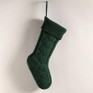 Detailed view of large green knitted Christmas stocking with classic cable knit patterns
