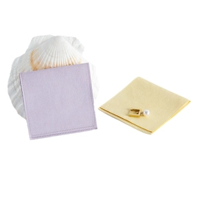 Soft velvet jewelry cleaning cloths in light purple and yellow with a decorative pearl earring