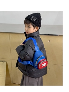 Detail showing the red and blue color-block children's crossbody bag with Cute embroidery