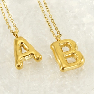 Detailed macro view of 18K gold plated balloon style A and B letter pendants on a chain