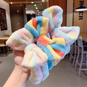 Detailed view of rainbow striped plush bow headbands for washing face and skincare